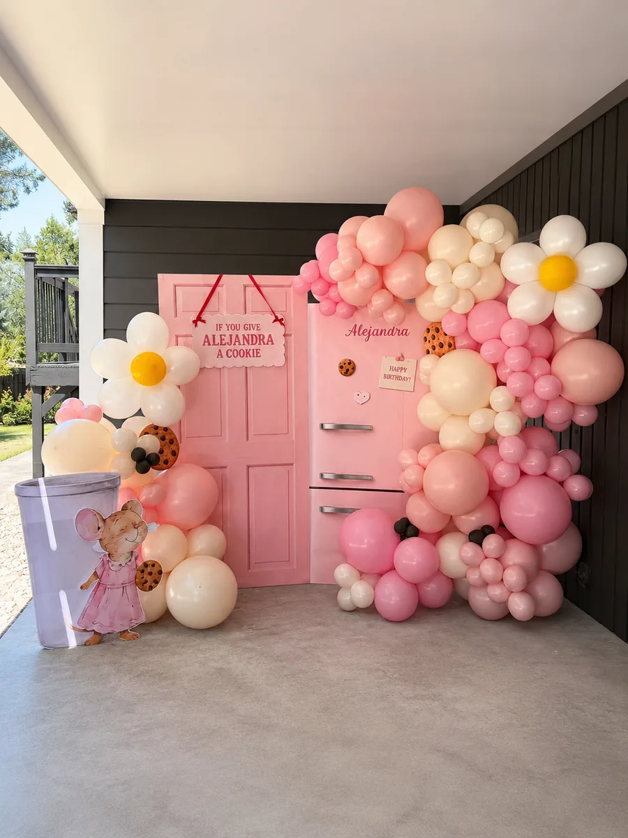 A Wildly & Co. balloon installation — pink daisy garland birthday backdrop